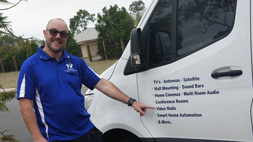 Technician pointing at the video walls service on the side of his van
