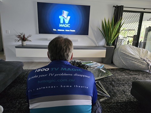 Technician in front of a home theatre setup he built.