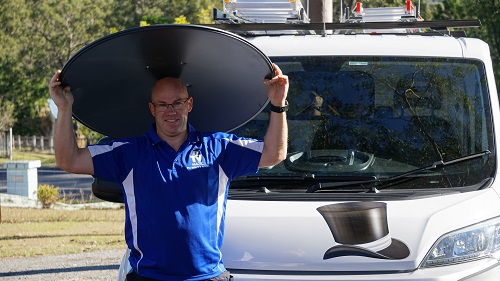 Technician - Carl, holding a satellite dish over his head.