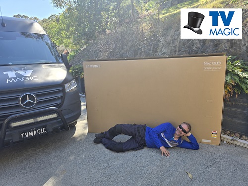Technician laying next to 100" TV