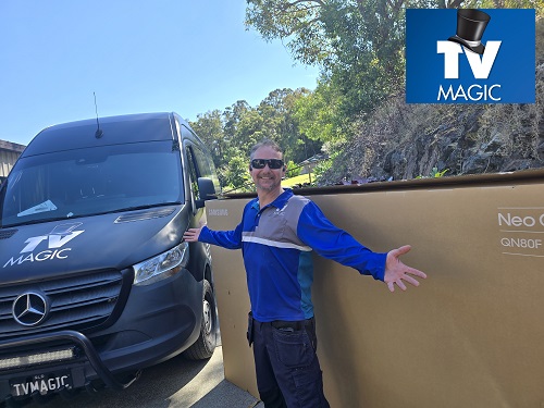 Technician with a big TV, ready for delivery