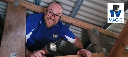Technician - Vaughan in a ceiling peforming a pre-wire fit out. TV Magic logo in top right corner.
