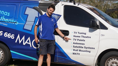 Technician - Alex, pointing to his services on the side of his van.