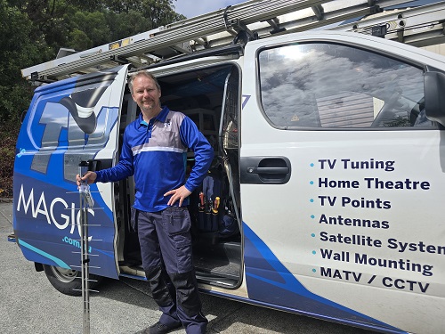 Technician next to his van with an antenna
