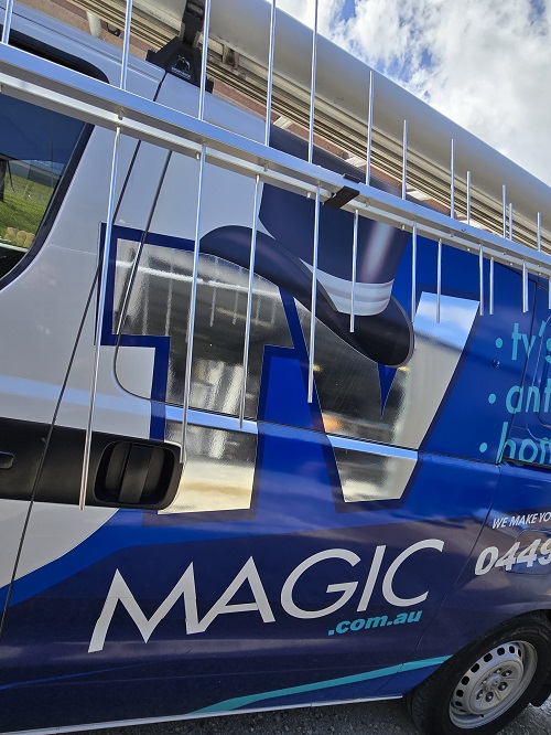 Side of TV Magic van with aerial next to it.