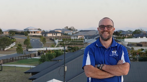 Technician up on a roof with an antenna he installed