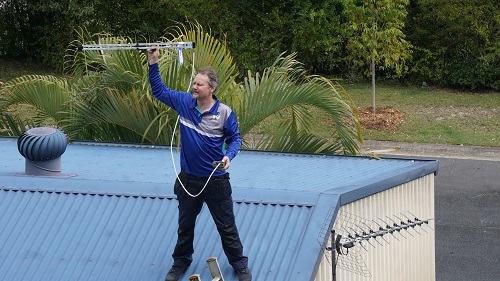 Technician on a roof with an antenna