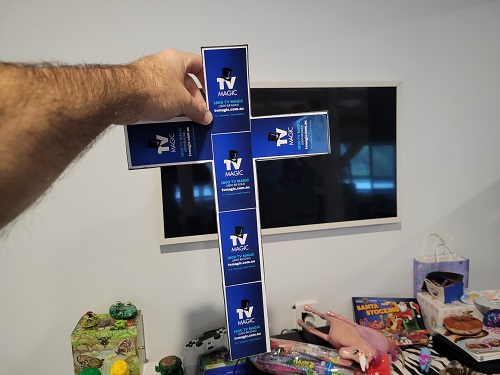 Cross made from TV Magic stickers, in front of a TV setup