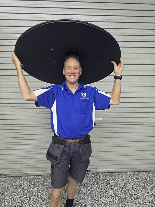 Technician - Robert holding a satellite dish over his head.