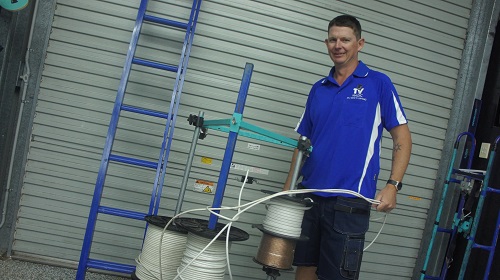 Technician standing with rolls of cables