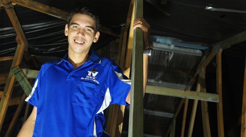 A technician in the roof of a house.
