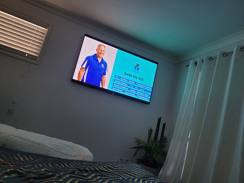 wall mounted TV with technician - Robert on screen with his services