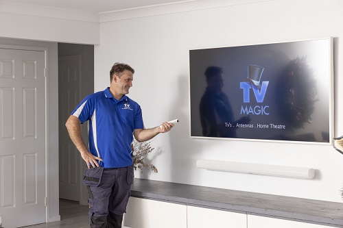 Technician setting up a soundbar in a customer living room.