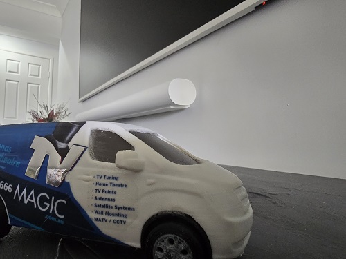 Close up of a mini TV Magic van under a floating soundbar.