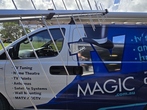 Side of TV Magic van with antenna in front of it.
