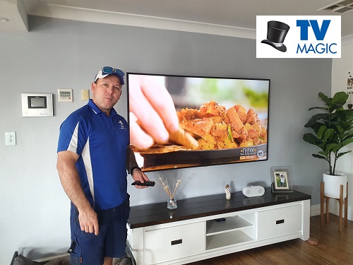 Technician - Matt with a TV he repaired the reception on.