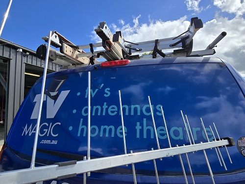 An antenna behind a TV Magic van