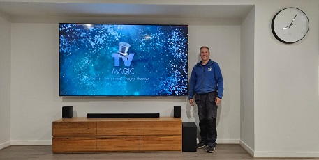 technician - Robert, standing in front of a massive wall mounted TV