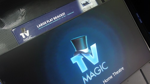 A Large TV on an angle with a TV Magic wall bracket on top