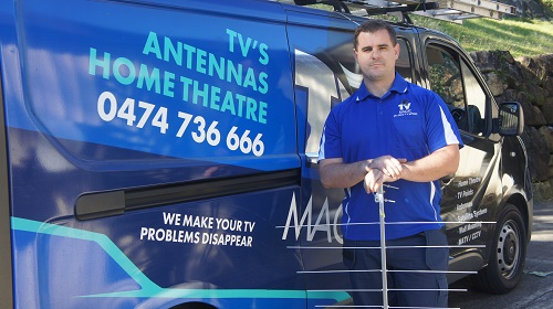 Technician standing next to his van with an antenna