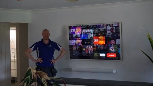 Technician in a customers living room, after finishing their home theatre setup