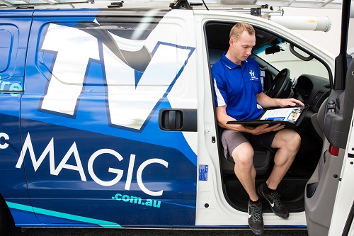 Technician looking in his TV Magic manual.