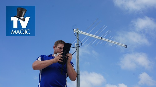 Technician testing an antenna to diagnose reception repair solution. TV Magic logo in top left corner