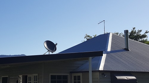 Tile roof with an antenna and satellite dish relocated by TV Magic