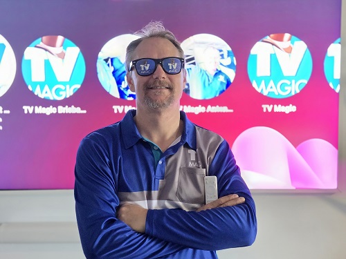 Technician - Jason in front of a large screen, wearing TV Magic sunglasses.