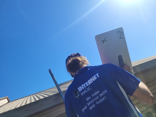 Technician climbing ladder onto roof to install Starlink