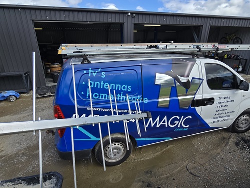 TV Magic van with antenna held up next to it