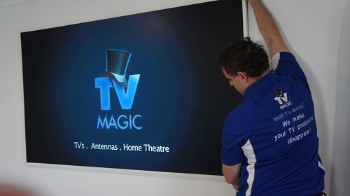 Technician installing and setting up a new TV