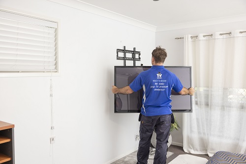 Technician preparing to wall mount a TV