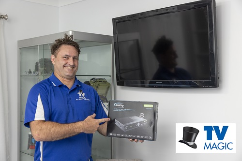 Technician with a Vast box, next to wall mounted TV