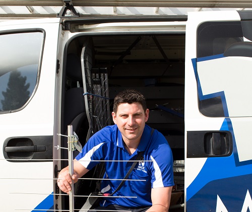 close up of technician - Sam, sitting in his van, holding an aerial