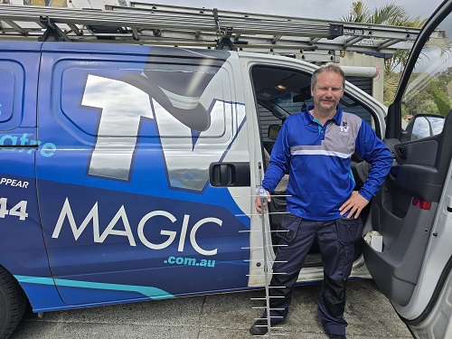 Technician standing with an aerial, next to his van