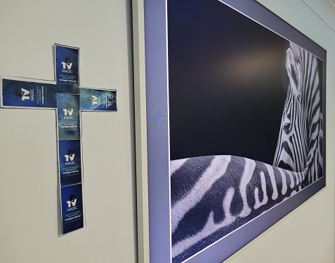 Large TV with zebra display. Cross made from TV Magic stickers next to it.
