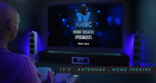 An image of a person in a TV Magic home cinema. Caption on screen "Home Theatre Specialists"