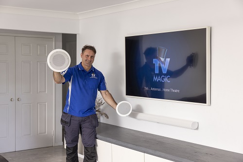 Technician holding speakers for a multi-room audio setup