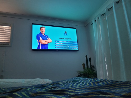 TV Mounted on a wall with technician details.