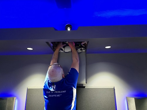Technician installing a motorised projector
