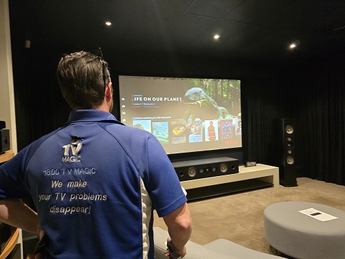 Technician in a home theatre post surround sound installation