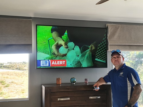Technician - Matt, standing in front of a wall mounted TV