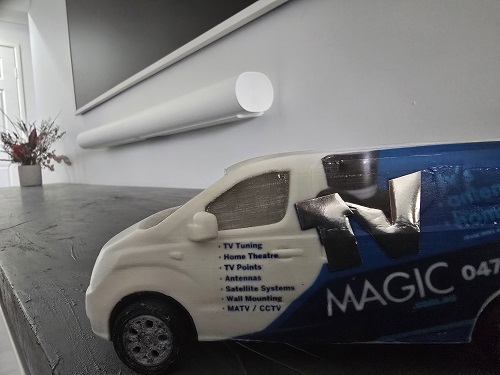 Tiny van below a wall mounted TV and soundbar