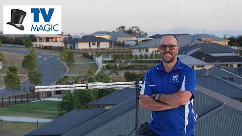 Technician on a roof with an antenna he just relocated
