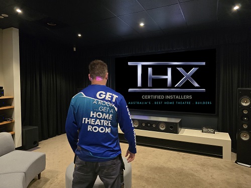Technician facing a home cinema by TV Magic.