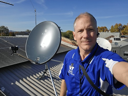Technician with a satellite dish installation he just completed.