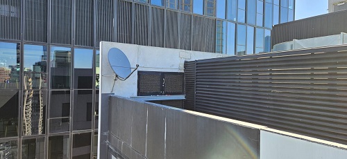 A satellite dish installation on side of building