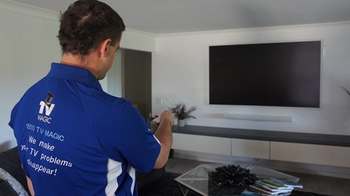 Technician setting up a soundbar he installed