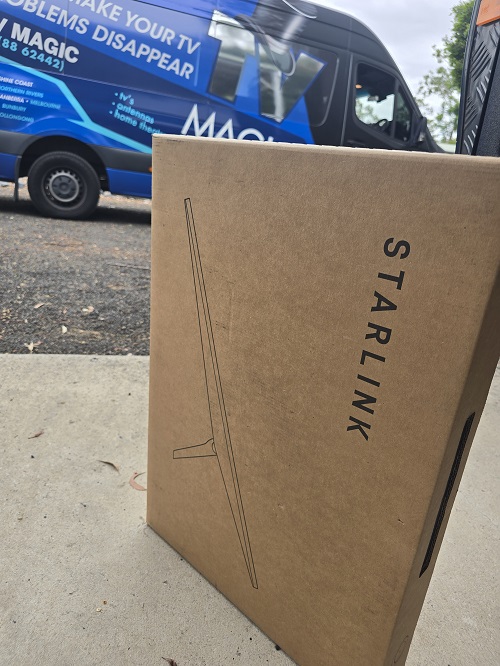 Close up of a Starlink kit,  in front of TV Magic van